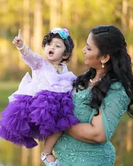 A mother and baby daughter in coordinated lavender and aqua occasion wear