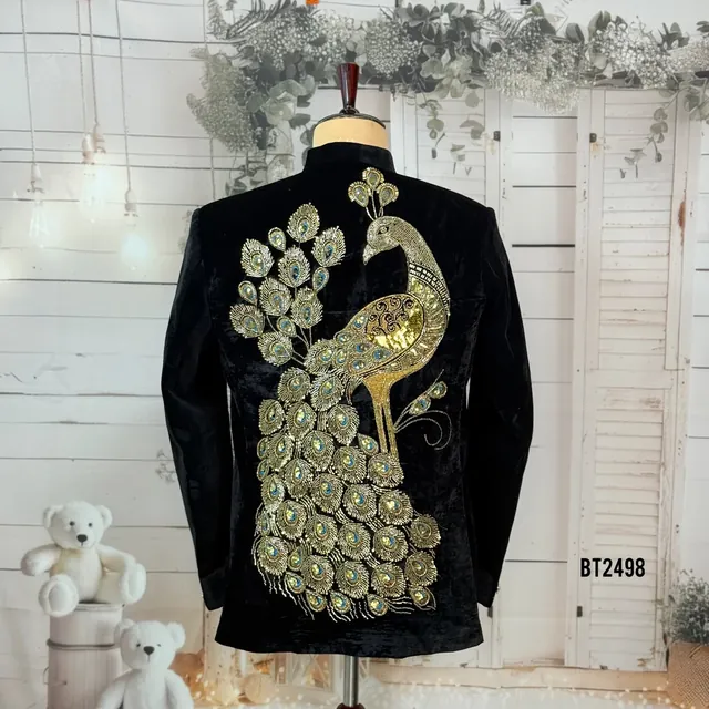 Gold peacock embroidery on a black velvet occasion coat, shown on a dress form